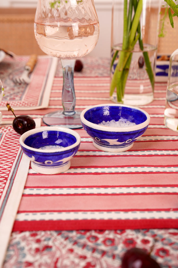 A duo of Jaipur pottery blue bowls on a dining table styled with block printed table linens