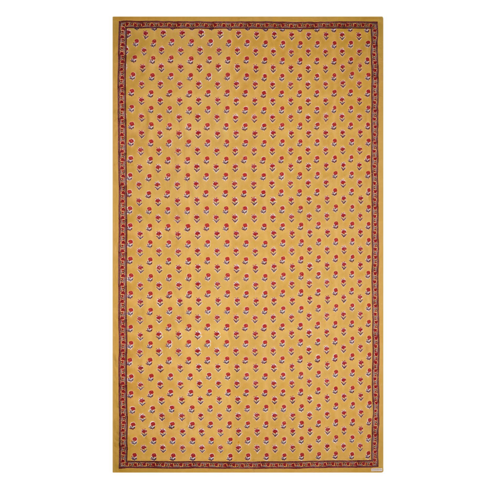 A rectangular tablecloth with a golden yellow base and small floral motifs, with a decorative border.