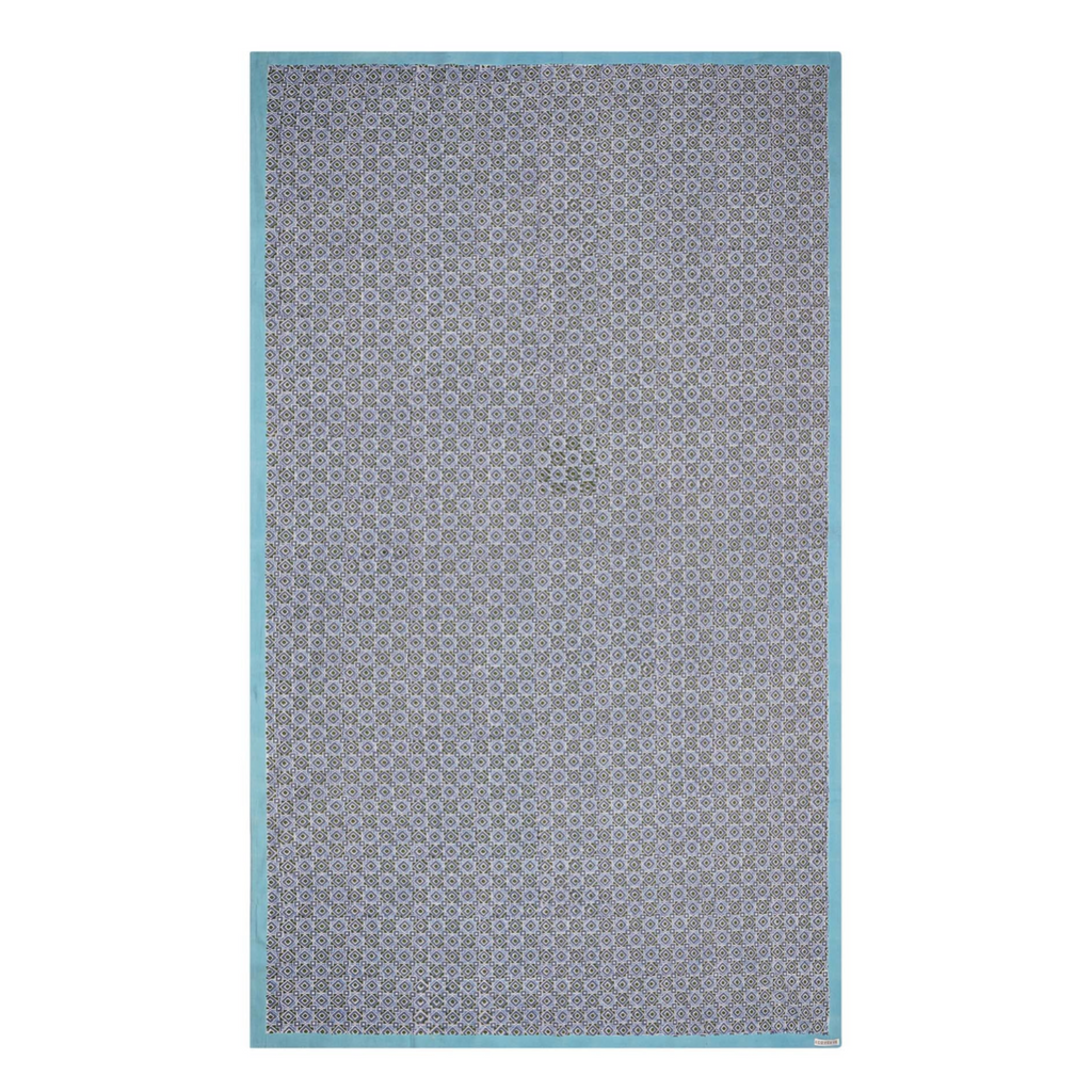 A rectangular tablecloth with a geometric pattern in shades of blue and green, with a solid white border.