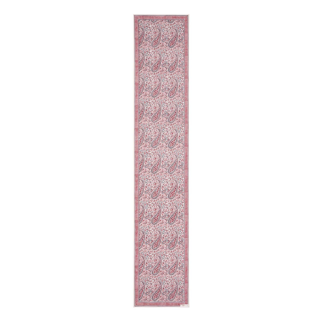 Long narrow block printed paisley design pink and white patterned table runner on a white background