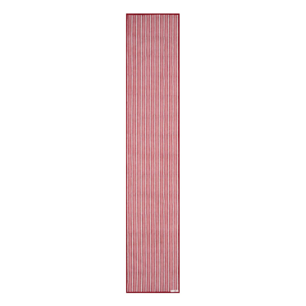A striped cotton table runner with a classic design, predominantly in red and white colors, displayed on a table.