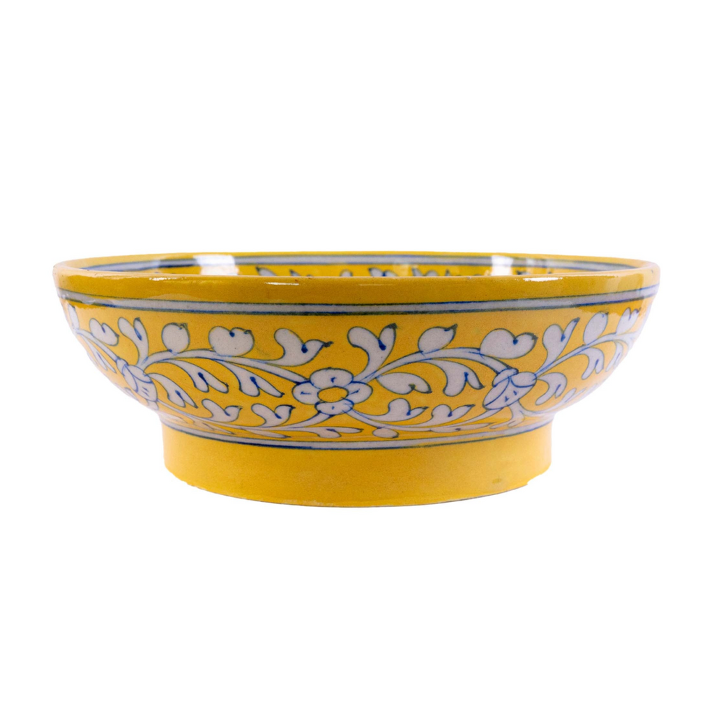 Yellow ceramic bowl with floral patterns on a white background