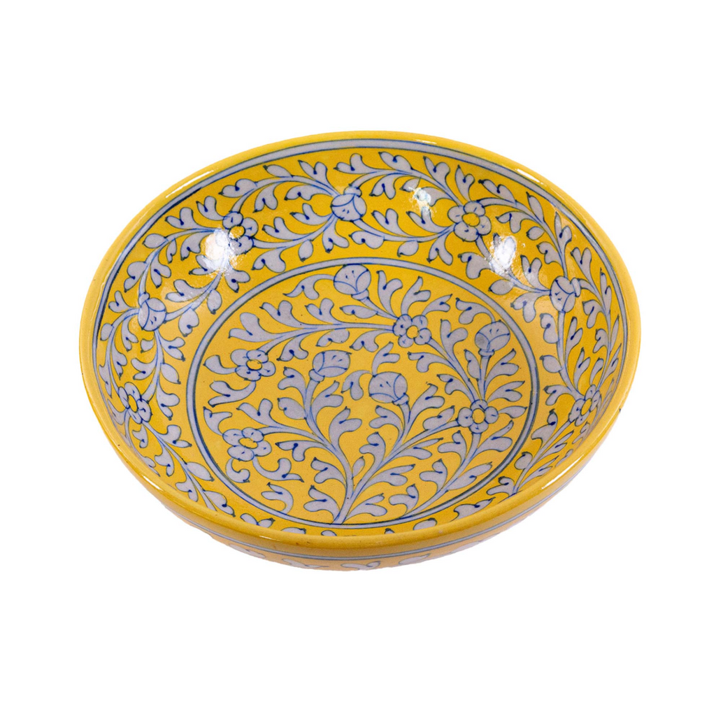 Yellow ceramic bowl with gray floral patterns on a white background